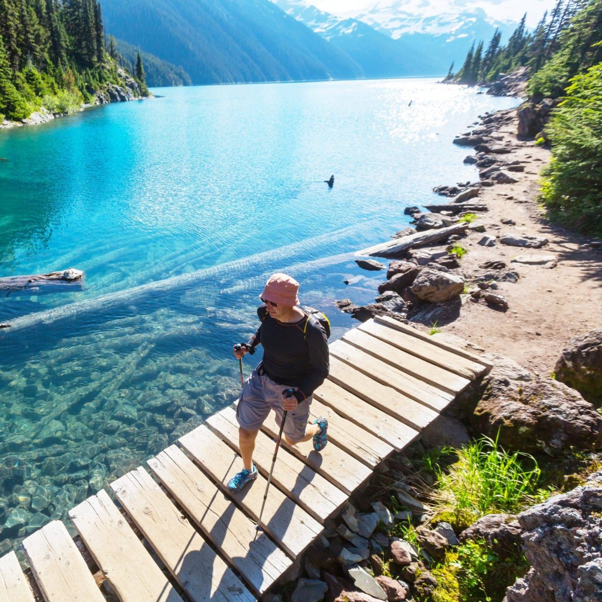 Explore outdoors and hike alongside a turquoise clear lake with mountain views in Vancouver, BC