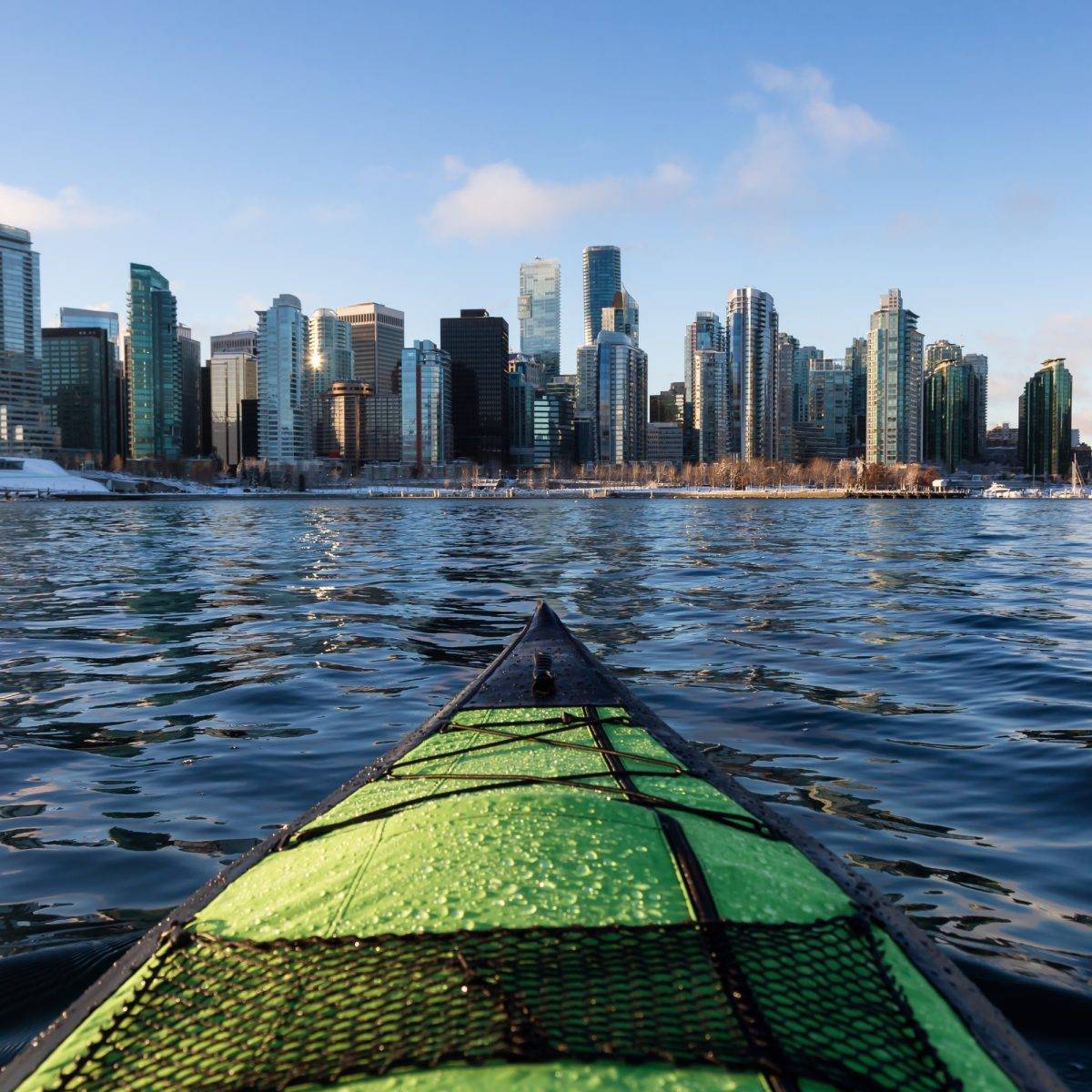 On a canoe in Vancouver seeing stunning buildings from the water.